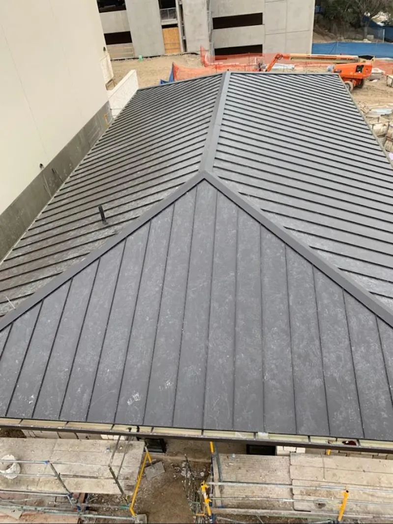 Commercial metal roof construction with crane equipment in North Little Rock